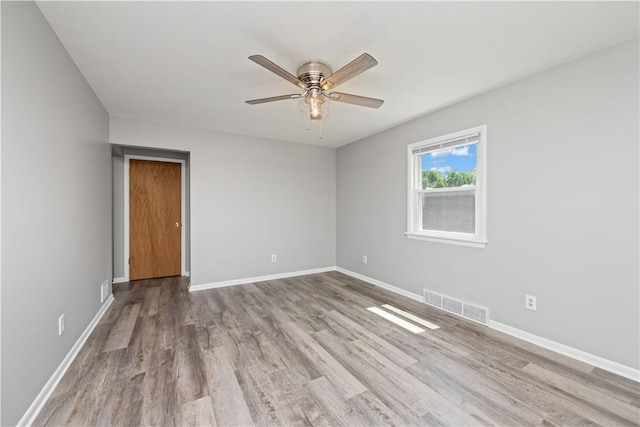 empty room featuring wood finished floors, ceiling fan, and baseboards