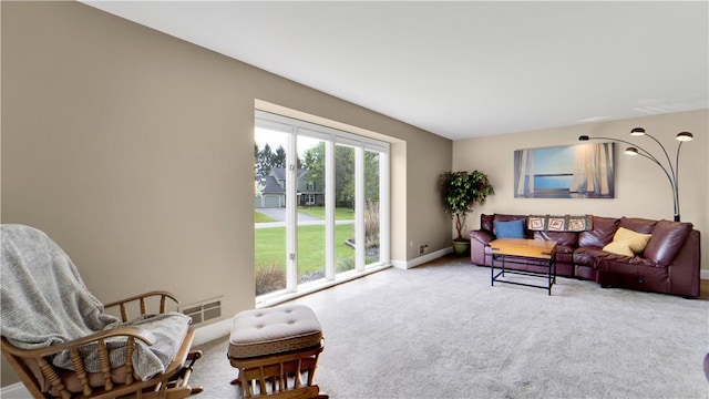 carpeted living area featuring baseboards