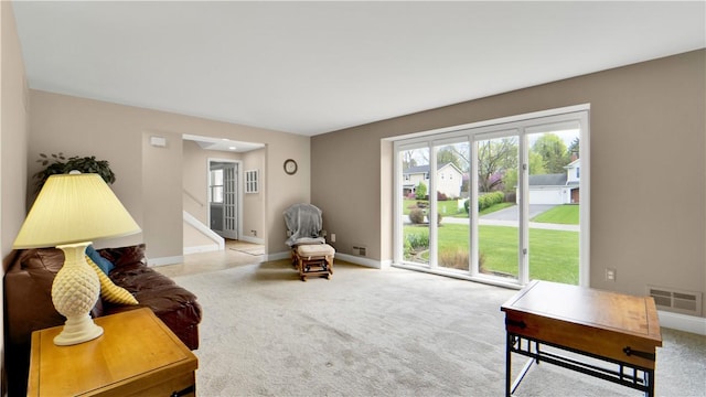 living area featuring plenty of natural light, carpet, and baseboards
