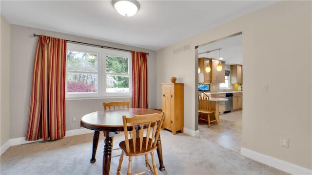 dining area with light carpet and baseboards