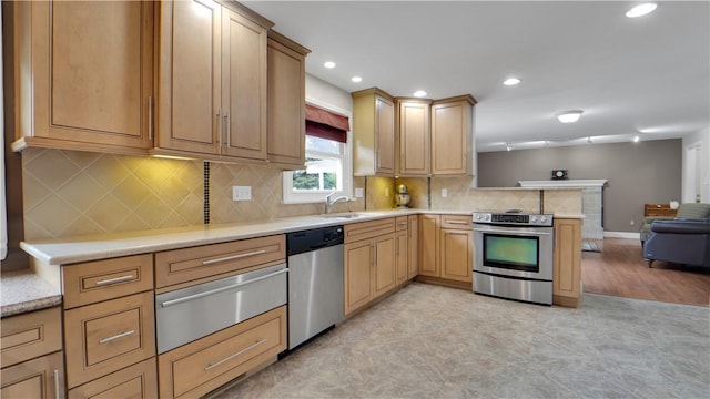 kitchen featuring appliances with stainless steel finishes, a warming drawer, a sink, a peninsula, and open floor plan
