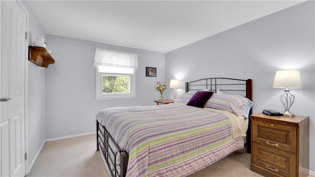bedroom featuring light carpet and baseboards