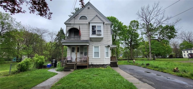221 Grace St, Syracuse, NY 13204 - victorian-style house featuring a front lawn, driveway, a balcony, and covered porch