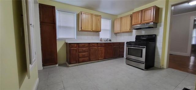221 Grace St, Syracuse, NY 13204 - kitchen featuring stainless steel range with gas stovetop, under cabinet range hood, decorative backsplash, light countertops, and a sink