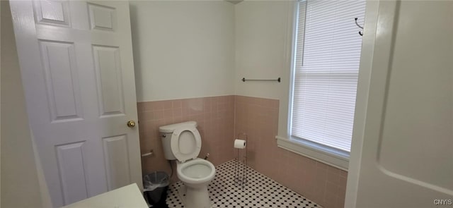 221 Grace St, Syracuse, NY 13204 - bathroom with tile walls, toilet, and wainscoting