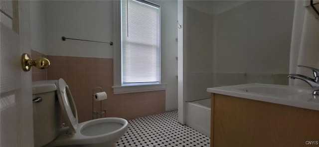 221 Grace St, Syracuse, NY 13204 - full bathroom featuring toilet, tile walls, vanity, a wainscoted wall, and tile patterned floors
