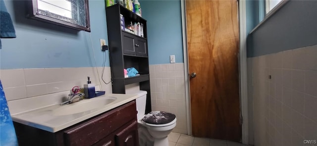 221 Grace St, Syracuse, NY 13204 - bathroom with tile walls, tile patterned floors, vanity, toilet, and wainscoting