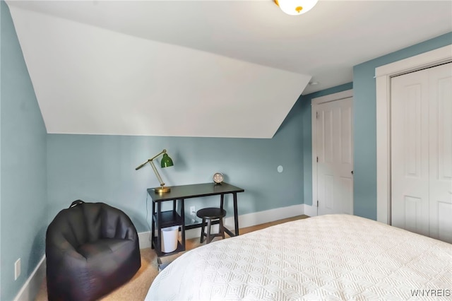 bedroom with baseboards, lofted ceiling, and a closet