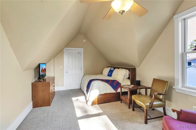 carpeted bedroom with vaulted ceiling, a ceiling fan, and baseboards