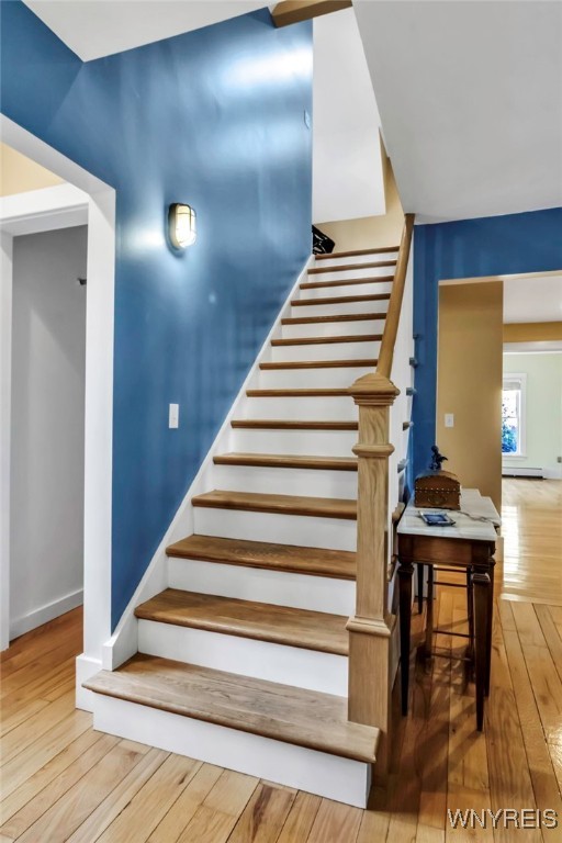 staircase featuring hardwood / wood-style flooring and baseboards