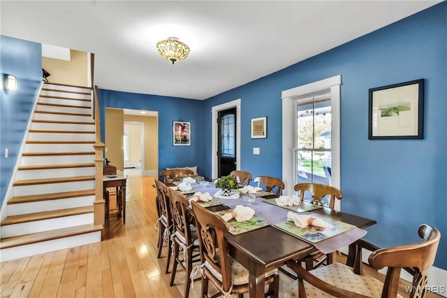dining area featuring stairs and light wood finished floors