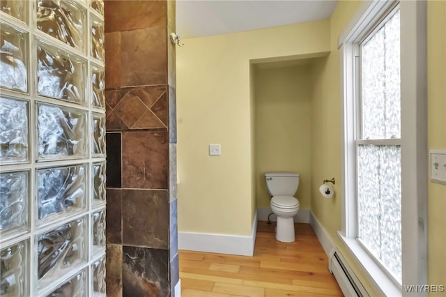 bathroom with a baseboard heating unit, wood finished floors, toilet, walk in shower, and plenty of natural light