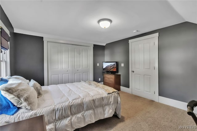 bedroom with a closet, carpet floors, baseboards, and lofted ceiling