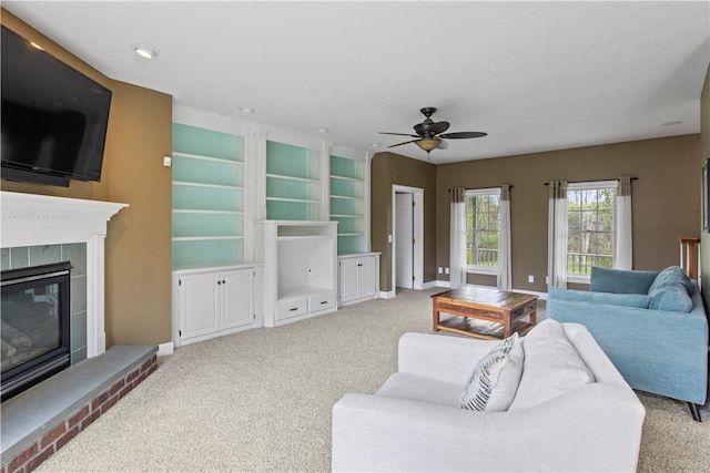 living area with carpet, a ceiling fan, a glass covered fireplace, baseboards, and recessed lighting