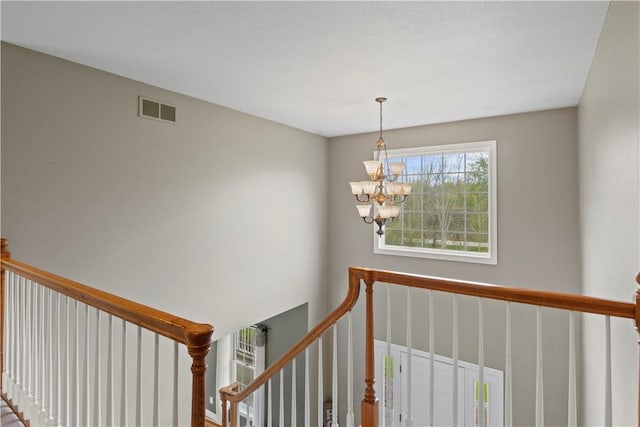 stairway with a chandelier