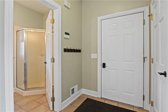 doorway with light tile patterned flooring and baseboards