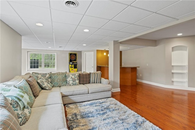living room with wood finished floors, built in shelves, baseboards, and recessed lighting
