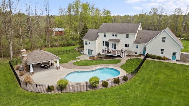 back of house featuring a deck, a gazebo, a view of trees, a chimney, and a shingled roof