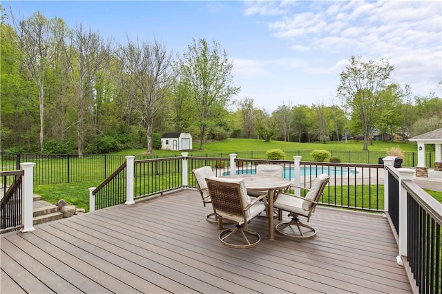 deck with a storage shed, outdoor dining area, and an outdoor structure