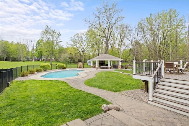 view of pool with a gazebo, a wooden deck, and view of wooded area