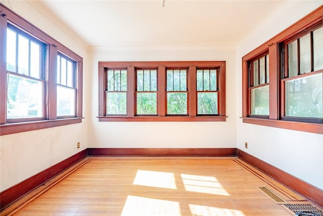 spare room with light wood-style flooring and baseboards