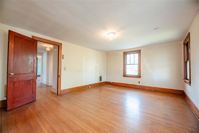 spare room with light wood-type flooring and baseboards