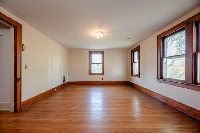 unfurnished room featuring light wood-style flooring and baseboards