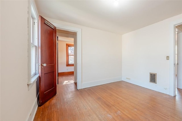 spare room with wood finished floors and baseboards