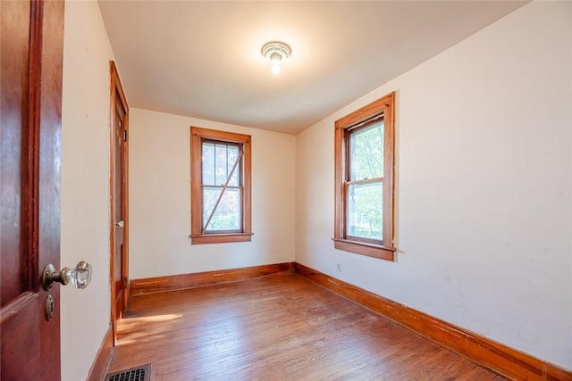 unfurnished room with wood finished floors and baseboards