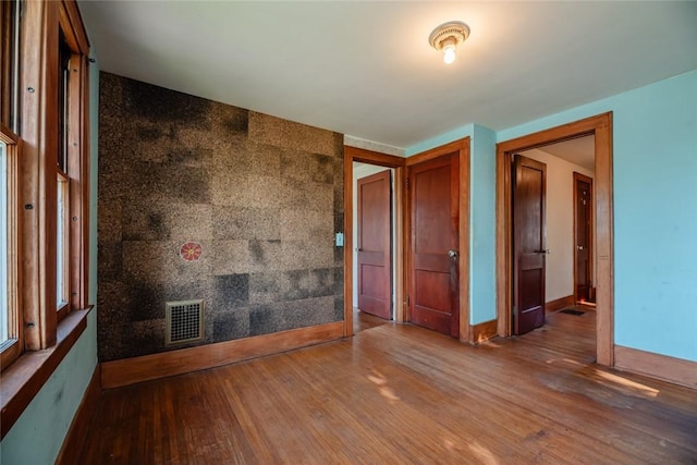 unfurnished room featuring wood finished floors and baseboards