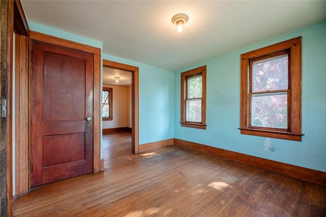 empty room featuring wood finished floors and baseboards