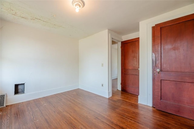 unfurnished bedroom featuring wood finished floors and baseboards