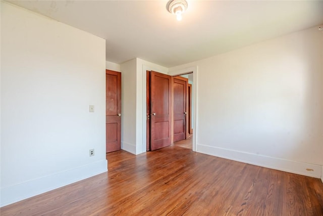 empty room featuring baseboards and light wood finished floors