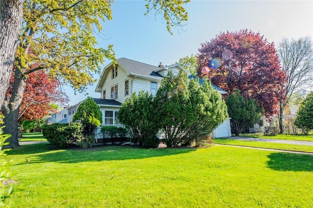 view of home's exterior featuring a lawn, asphalt driveway, and a garage