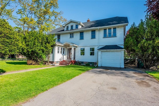 view of front of home with an attached garage, a chimney, driveway, and a front lawn