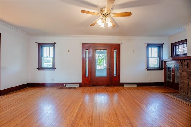 foyer entrance with wood finished floors, crown molding, baseboards, and ceiling fan