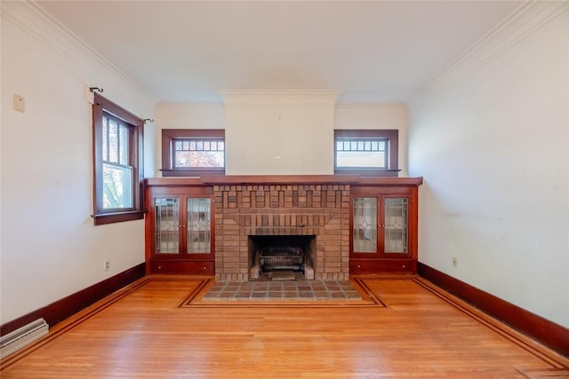 unfurnished living room featuring wood finished floors, a baseboard radiator, crown molding, a fireplace, and baseboards
