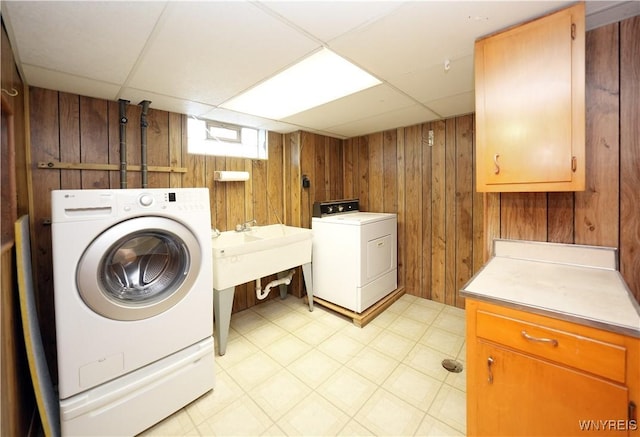 41 Della Dr, Lackawanna, NY 14218 - laundry room with washing machine and clothes dryer, cabinet space, wooden walls, and light floors