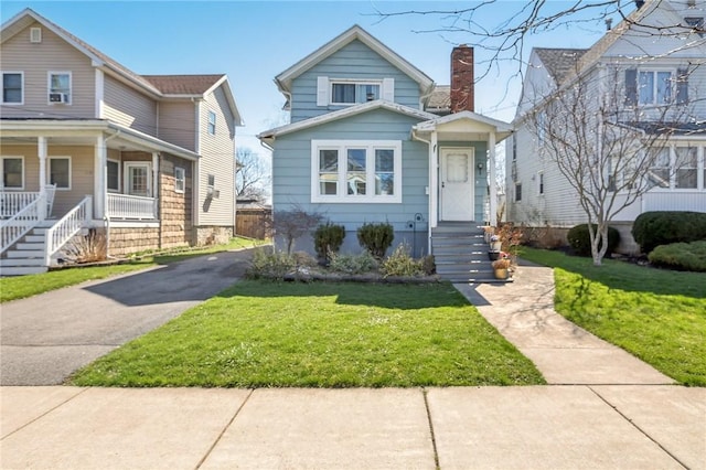 136 Summit St, Batavia-City, NY 14020 - view of front of home featuring a front yard, a chimney, and asphalt driveway