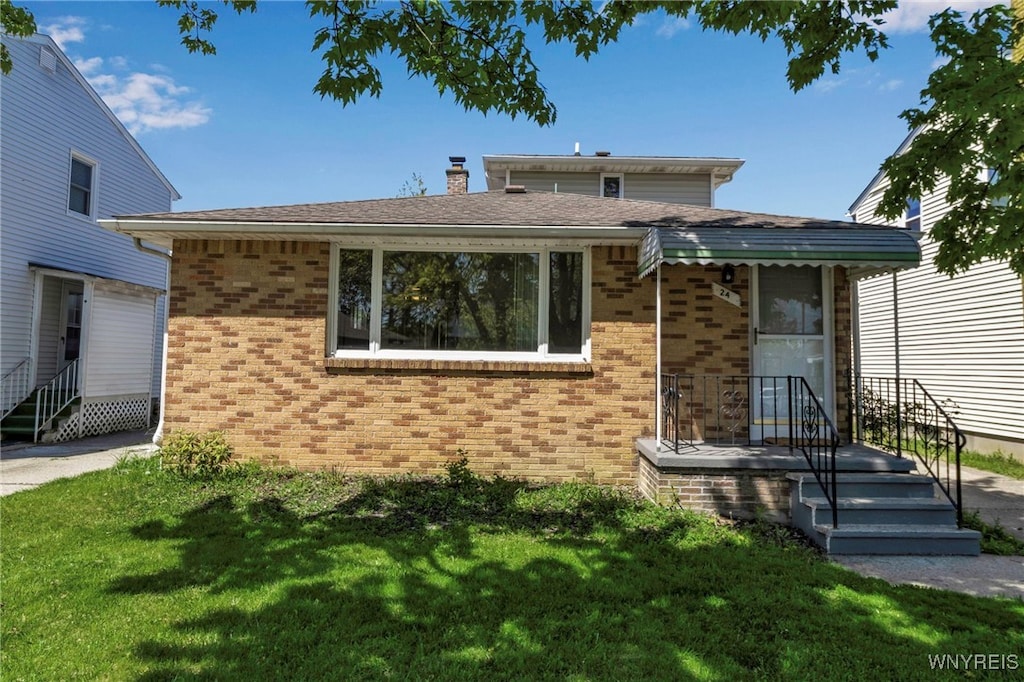 24 Leonore Rd, Amherst, NY 14226 - view of front of property featuring brick siding, a front yard, and a chimney