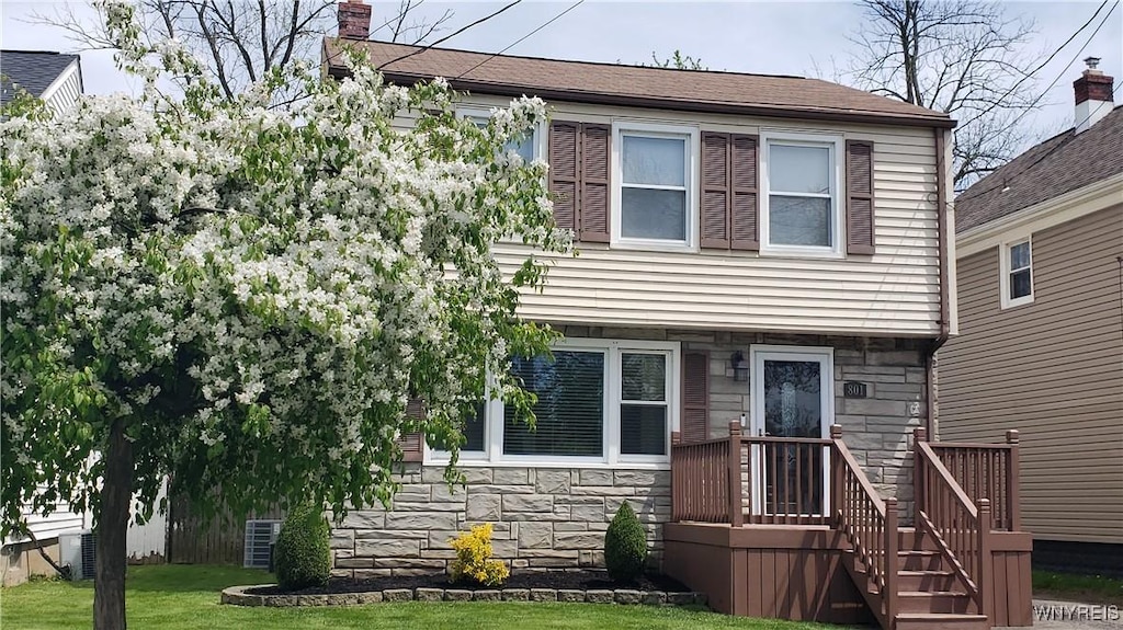 801 91st St, Niagara Falls, NY 14304 - view of front of home featuring stone siding, a chimney, cooling unit, and a front lawn
