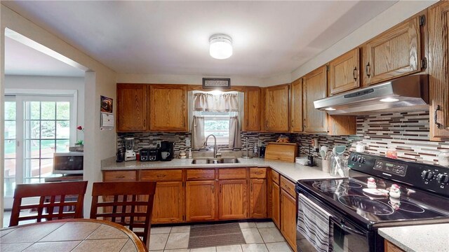 6 Club View Dr, Bath, NY 14810 - kitchen featuring black range with electric stovetop, a sink, under cabinet range hood, light countertops, and healthy amount of natural light