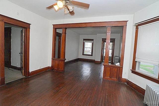 54 Pine Ridge Rd, Cheektowaga, NY 14211 - unfurnished room featuring radiator, wood-type flooring, decorative columns, and baseboards