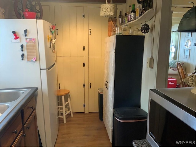 13202 Park Rd, Carlton, NY 14571 - kitchen with freestanding refrigerator, light wood-style floors, and dark countertops