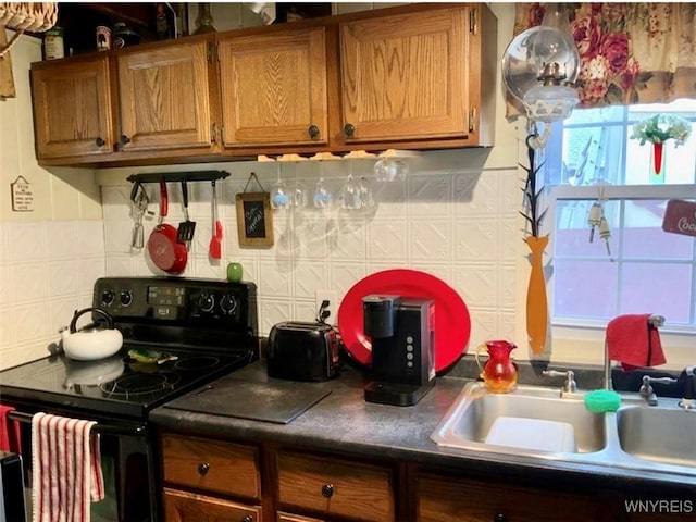 13202 Park Rd, Carlton, NY 14571 - kitchen featuring black electric range, brown cabinets, tasteful backsplash, and dark countertops