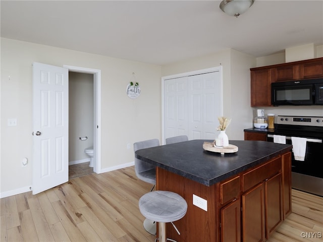 10029-10033 Ash St, Pamelia, NY 13601 - kitchen with black microwave, stainless steel range with electric stovetop, dark countertops, and light wood finished floors