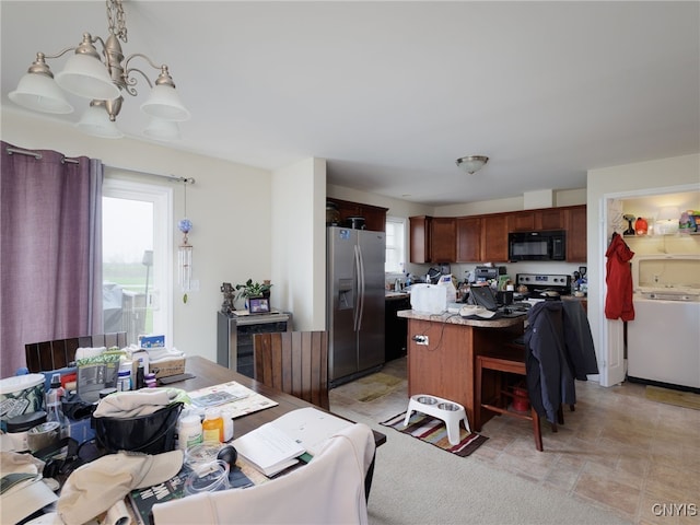 10029-10033 Ash St, Pamelia, NY 13601 - kitchen with appliances with stainless steel finishes, a center island, light countertops, a kitchen breakfast bar, and washer / clothes dryer