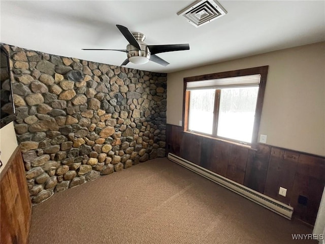 1068 Meiser Rd, Alabama, NY 14036 - spare room featuring wainscoting, a baseboard radiator, ceiling fan, carpet floors, and wood walls
