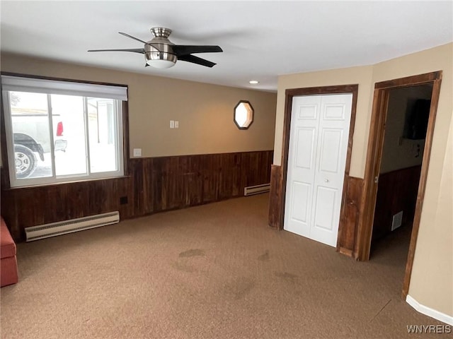 1068 Meiser Rd, Alabama, NY 14036 - spare room with baseboard heating, wooden walls, carpet flooring, wainscoting, and ceiling fan