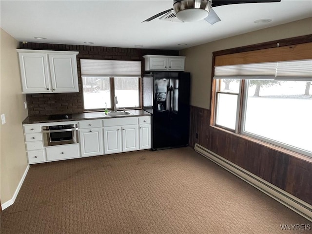 1068 Meiser Rd, Alabama, NY 14036 - kitchen featuring stainless steel oven, black fridge, ceiling fan, a baseboard heating unit, and a sink